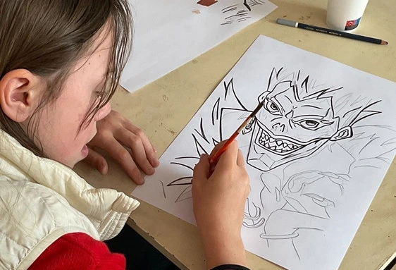 Jeune dessinant un manga